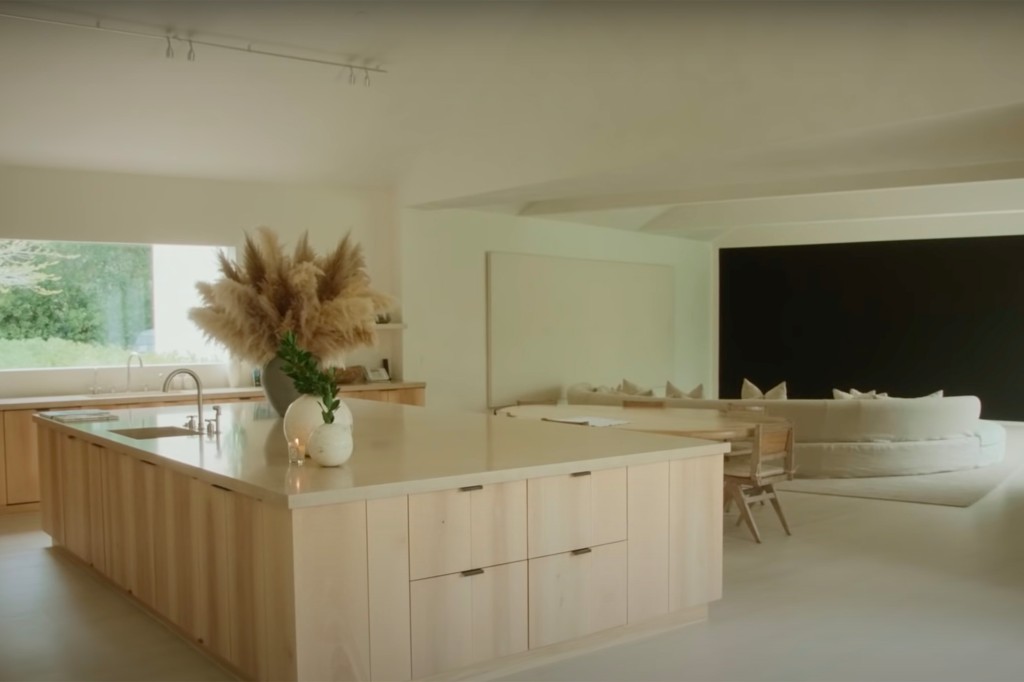 La cucina calmante di Kim!  La zona cottura presenta un piano di lavoro in marmo bianco e armadi in legno chiaro.  La cucina a pianta aperta si affaccia sull'area salotto.