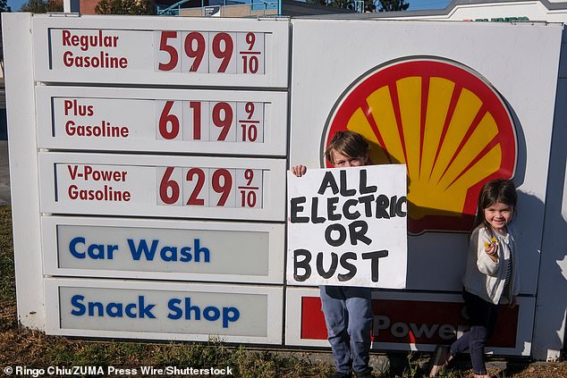 La gente tiene cartelli per protestare contro l'aumento dei prezzi del gas in una stazione di servizio Shell a Santa Monica, in California, sabato