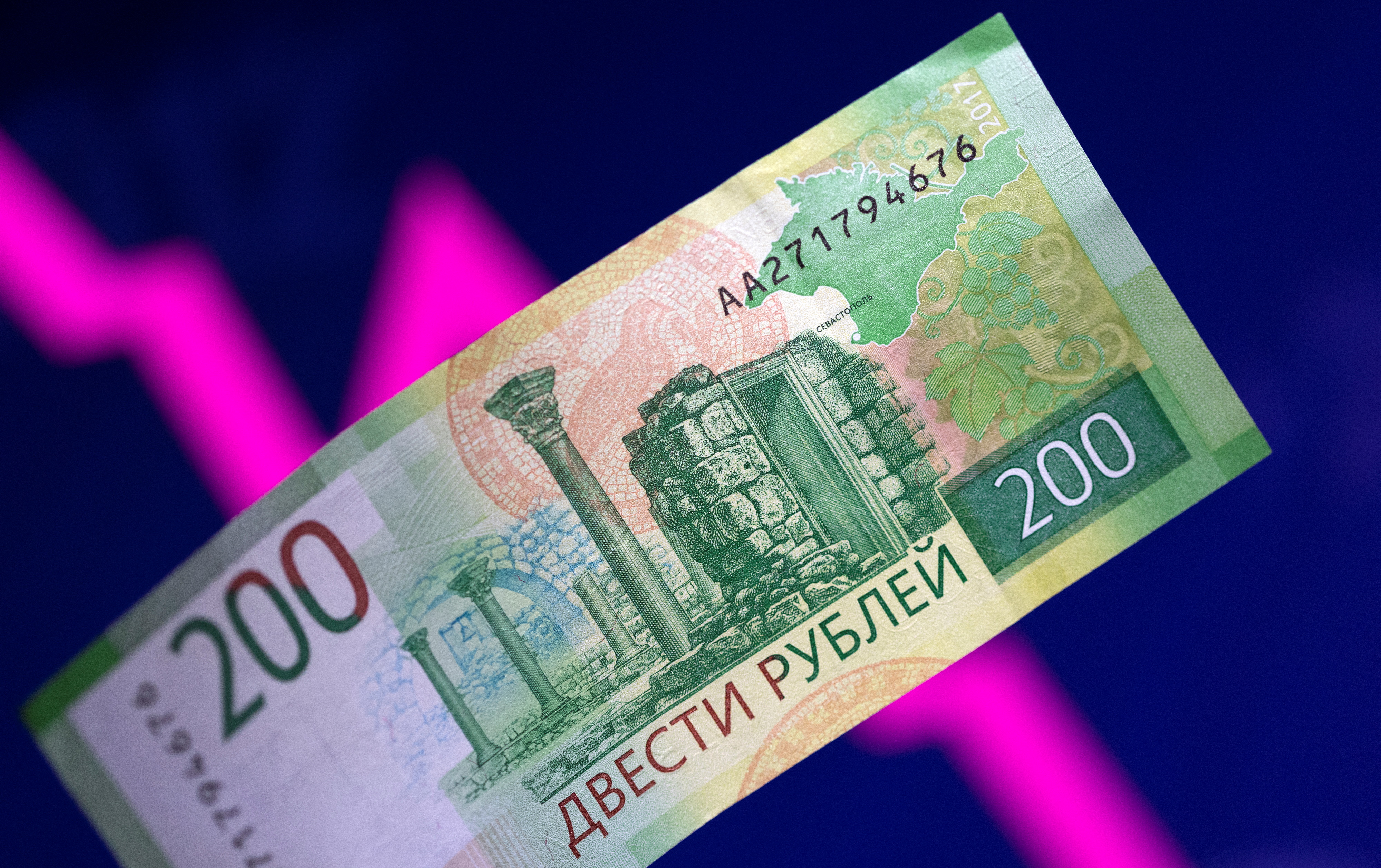 L'illustrazione mostra una banconota in rubli russi e un grafico a freccia discendente