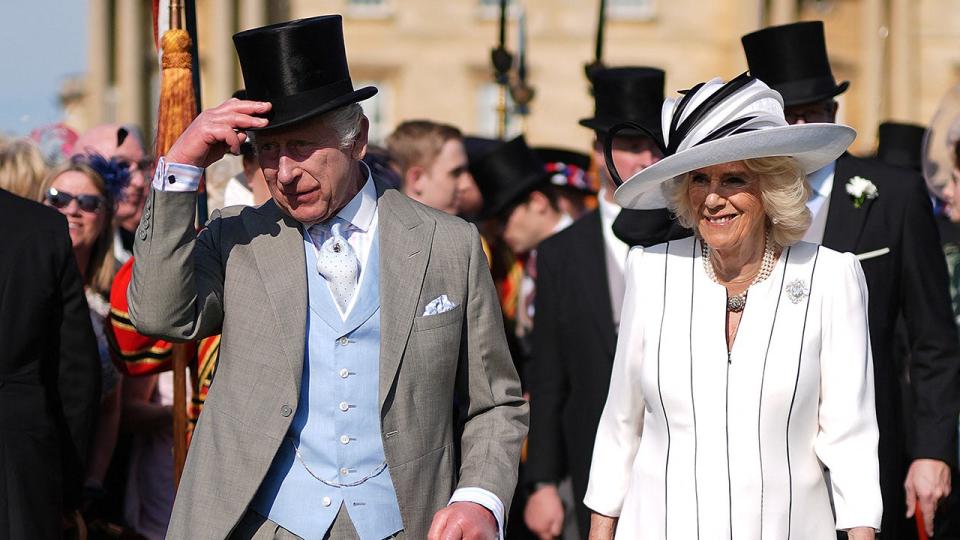Re Carlo alza il cappello accanto alla sorridente regina Camilla
