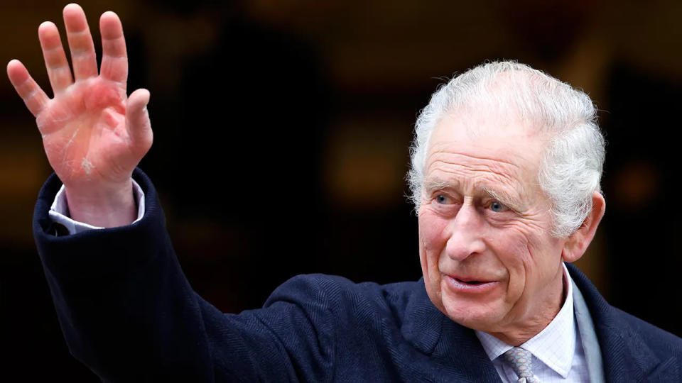 Re Carlo indossa un abito blu scuro e saluta gli spettatori mentre lascia una clinica londinese