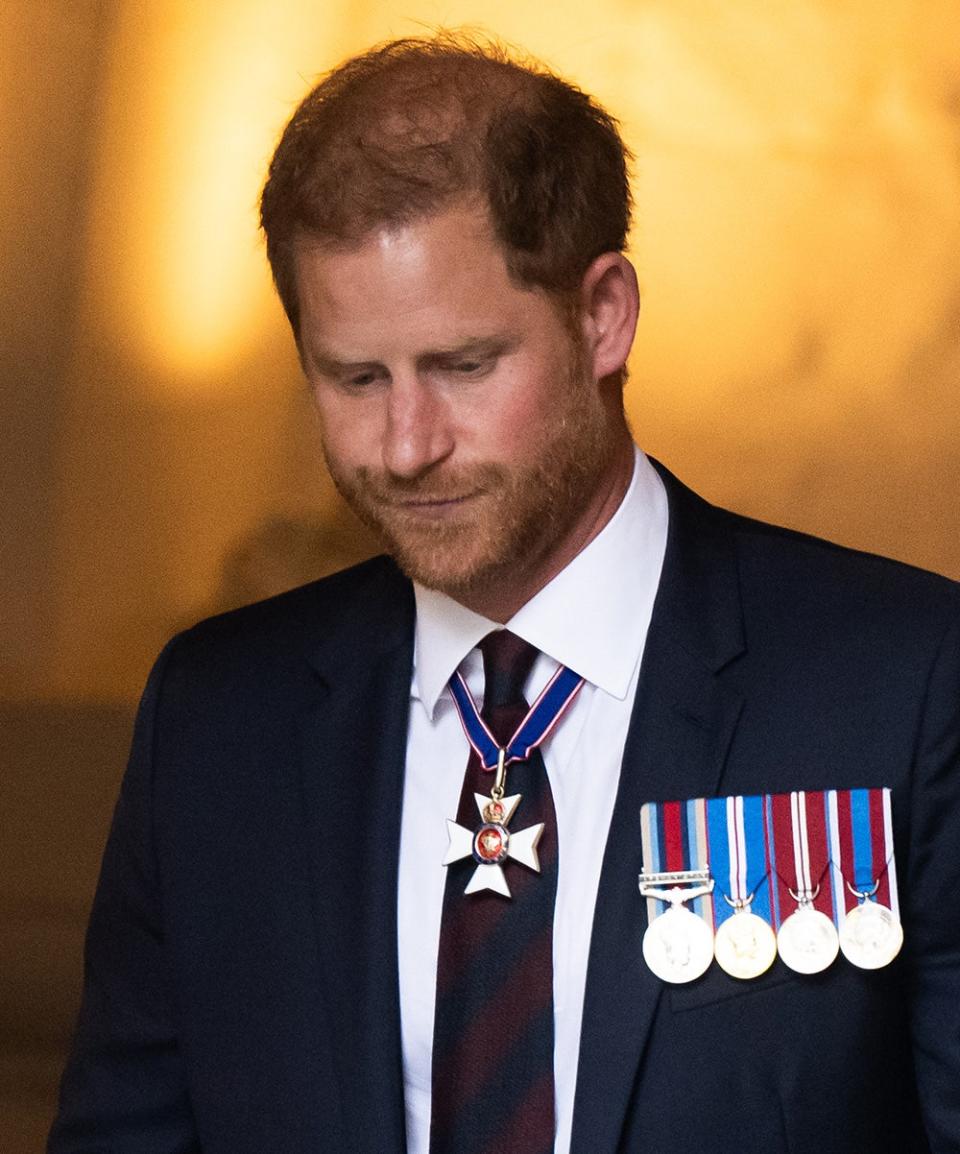 Il principe Harry abbassa lo sguardo indossando un abito con medaglie